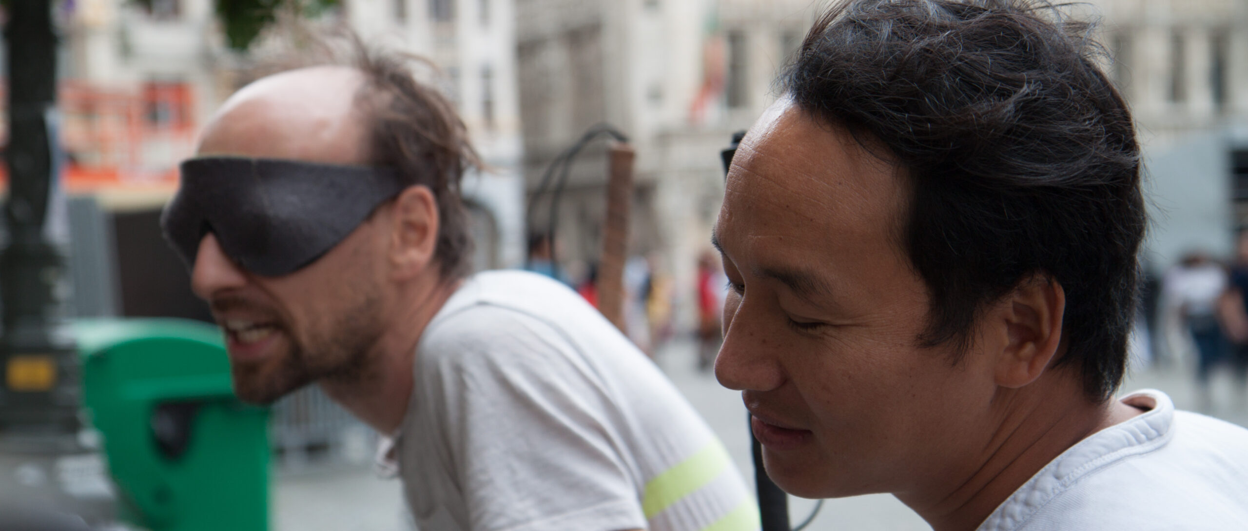 Deux hommes tendent l'oreille, l'un est aveugle, l'autre porte un bandeau.